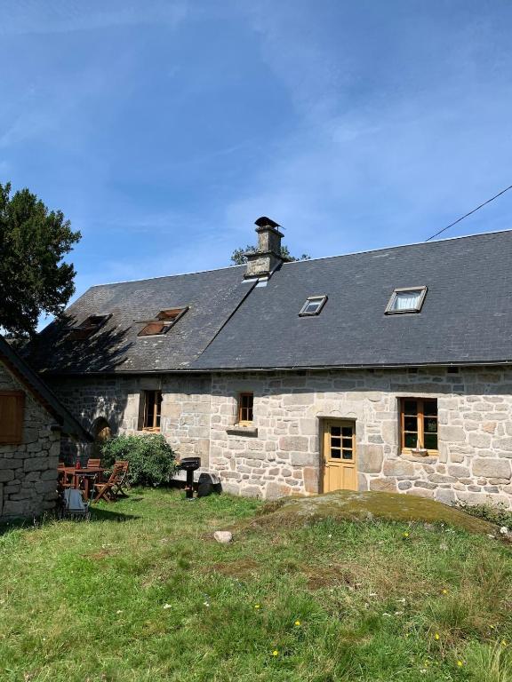 an old stone house with a black roof at La maison de Baptiste La Monédière in Chaumeil