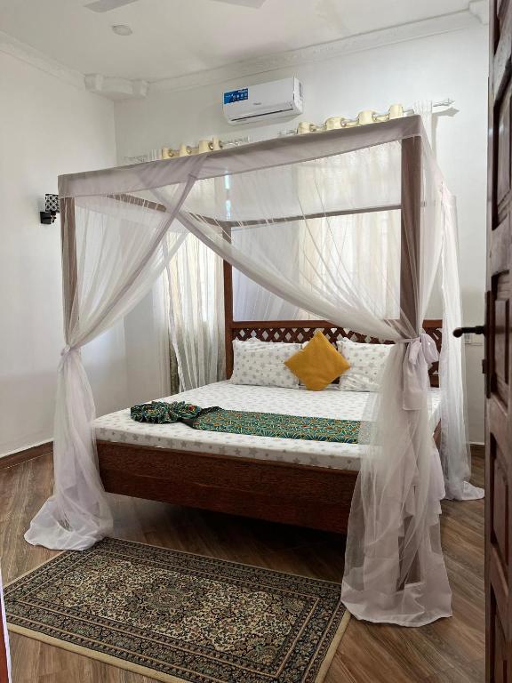 a bed with a canopy in a room at Sisters House in Pingwe