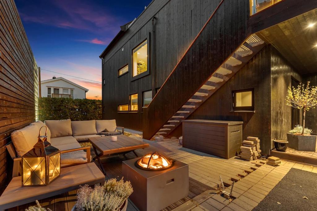 un patio con sofá y fogata en Lillestrøm , the studio flat, en Kjeller