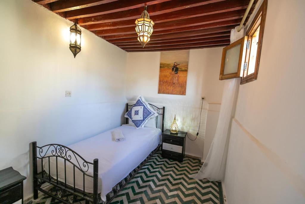 une petite chambre avec un lit et une fenêtre dans l'établissement Dar El Kendil, à Fès