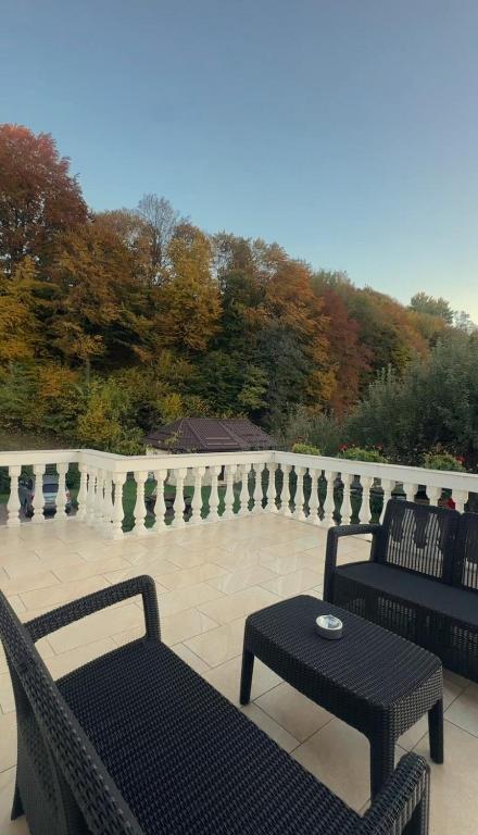 Un patio con dos sillas y una mesa y un banco. en Pensiunea Ionela, en Moieciu de Jos
