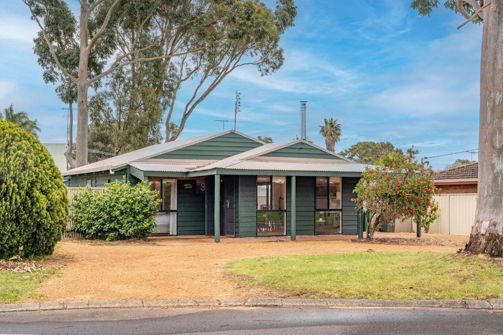 a green house with a tree in front of it at Chrissie's Cottage in Dunsborough