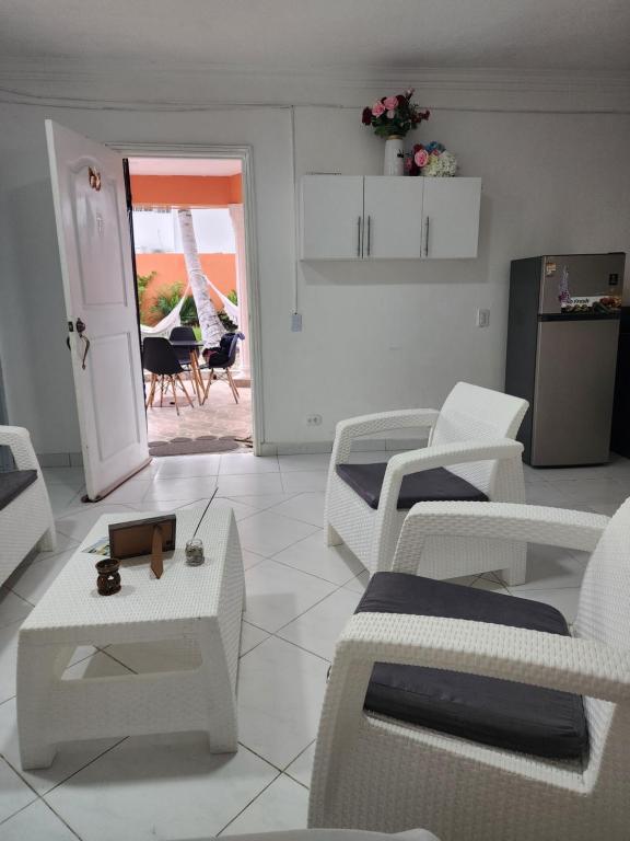 ein weißes Wohnzimmer mit weißen Stühlen und Tischen in der Unterkunft Cómodo y cerca de la playa in Punta Cana