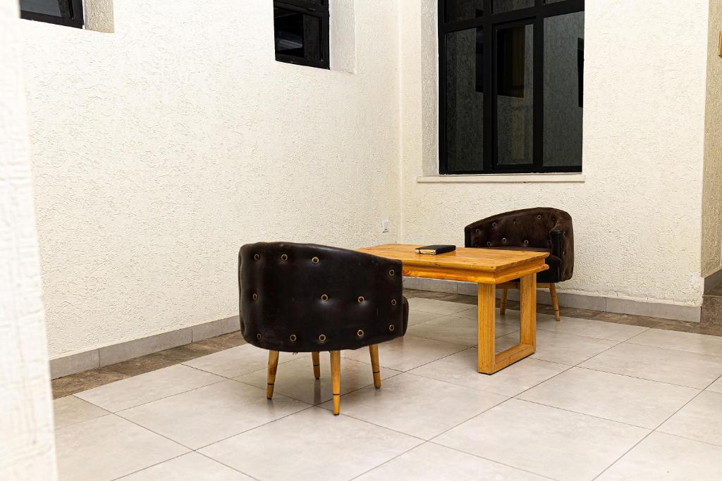 a table and two chairs sitting next to a wall at RP Gorilla Guest & Coffee in Taba