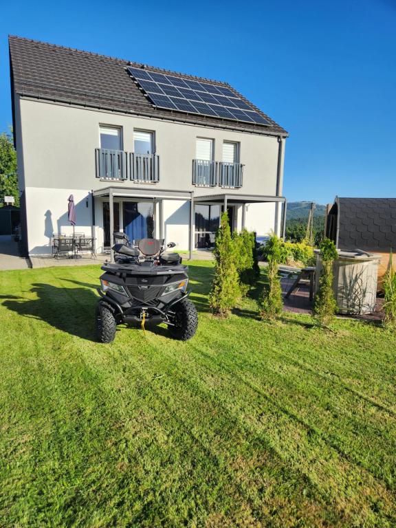 a wheeler parked in front of a house at willa Przystań Family SPA pod Ochodzitą in Koniaków