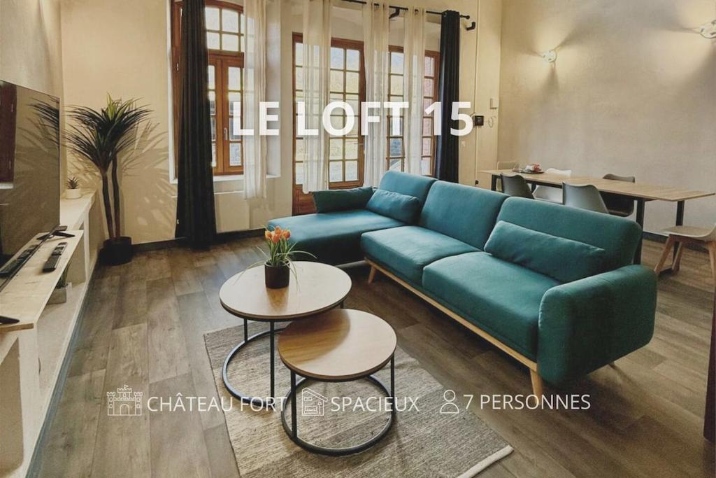 een woonkamer met een blauwe bank en een tafel bij Le Loft 15 - Château Fort in Mercury