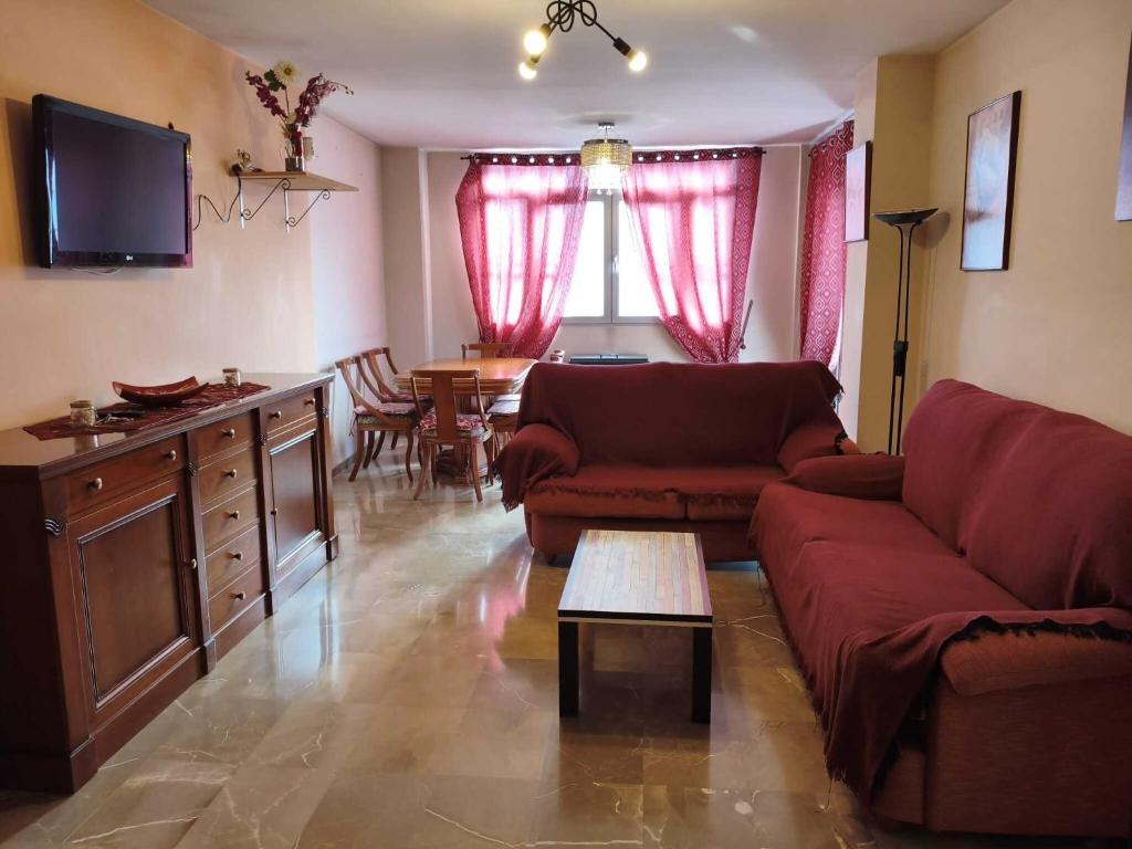 una sala de estar con un sofá y una mesa en House atarfe ii motril, en Atarfe