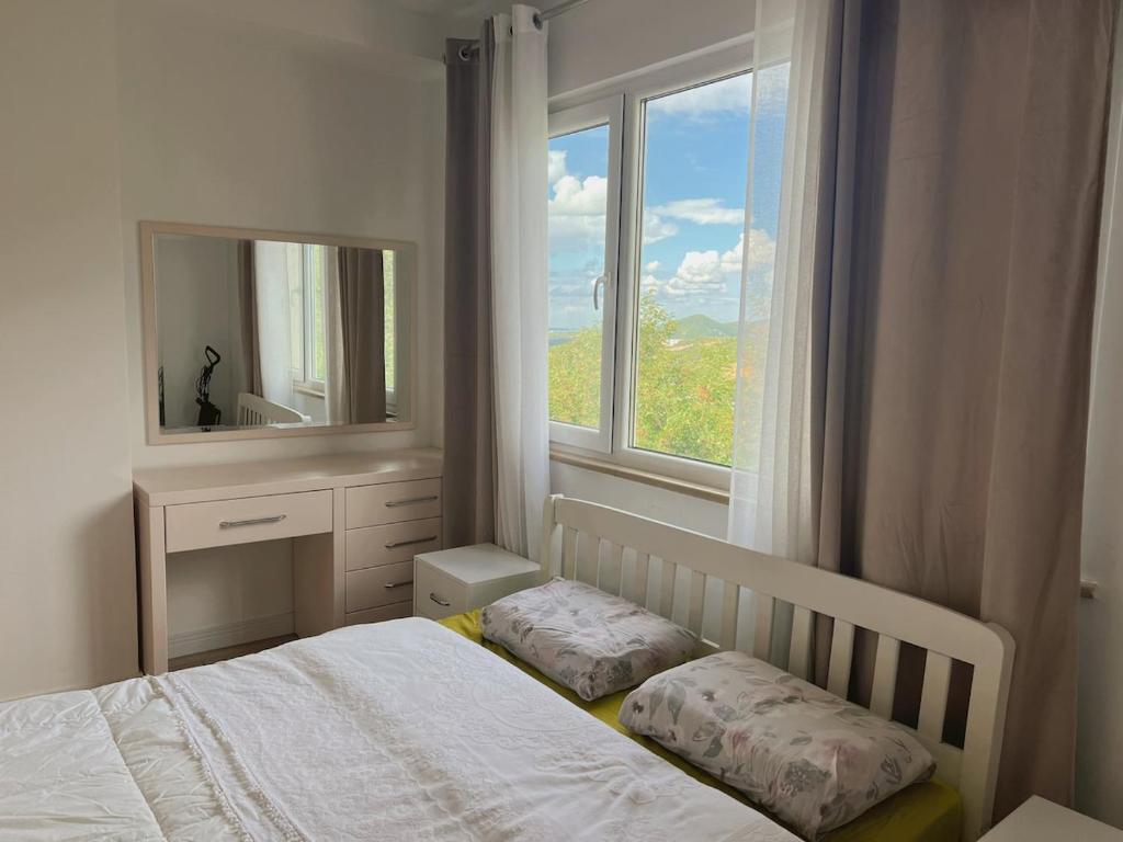 a bedroom with a bed with a mirror and a window at Up in Tirana Apartment in Tirana