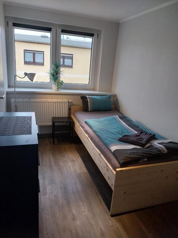 a bedroom with a bed in a room with a window at Einzelzimmer mit Bad HG 3 in Zwickau
