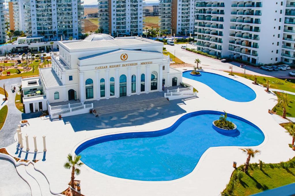 ein großes weißes Gebäude mit zwei Swimmingpools in der Unterkunft Luxurious Apartment with Pool View at Caesar Resort Am32 in Perivolia tou Trikomou