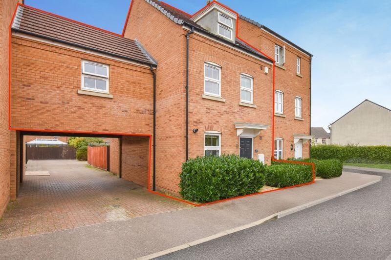 a brick building with a garage in front of it at Your 4 Bedroom Townhouse - Superking Bed in Stamford
