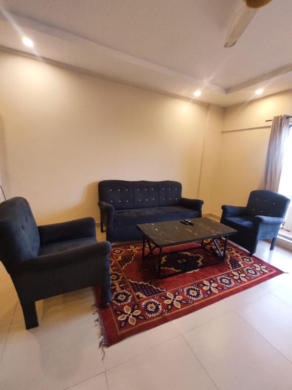 sala de estar con sofás, mesa y alfombra en One bedroom Apartment - Cube Apartment, en Islamabad