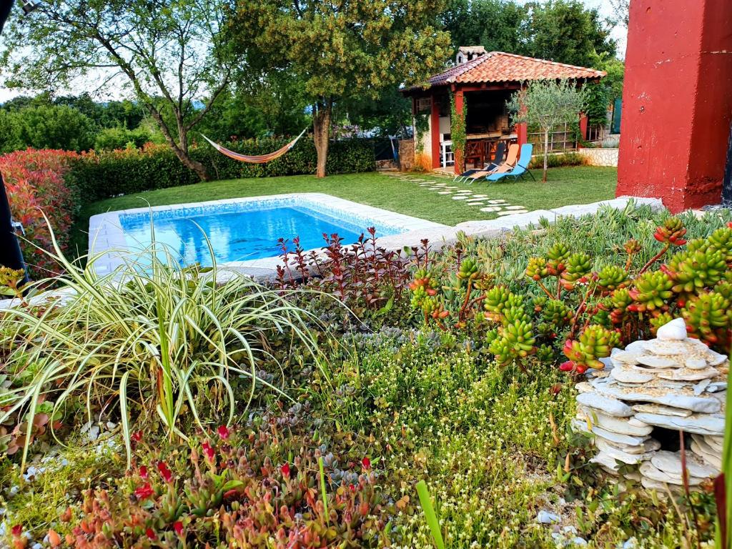 ein Garten mit Swimmingpool und Pavillon in der Unterkunft LaRossa House in Dobrinj