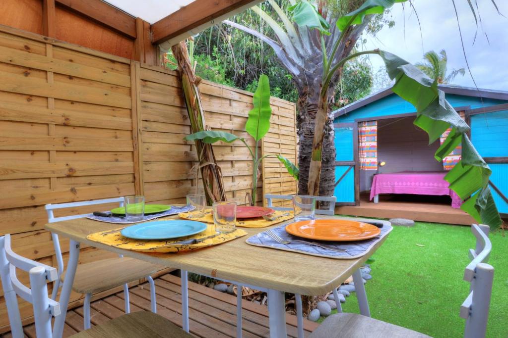 a wooden table with plates of food on a patio at Ti Kaz Maloya - Saint Paul in Saint-Paul