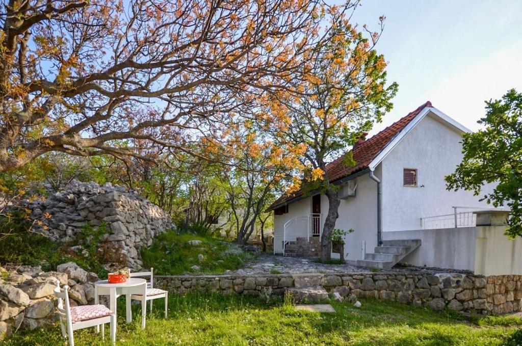 a white house with a table and chairs in front of it at Apartments Nina in Stinica