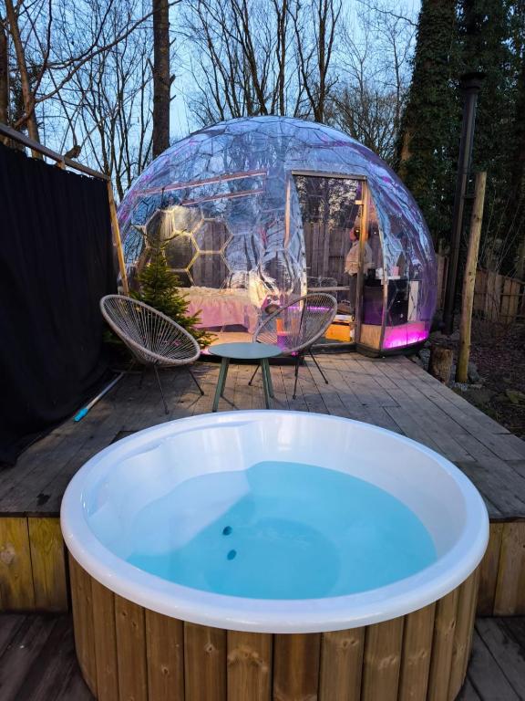 a jacuzzi tub on a deck with a tent at Dôme design by Out & Lodge in Couvin