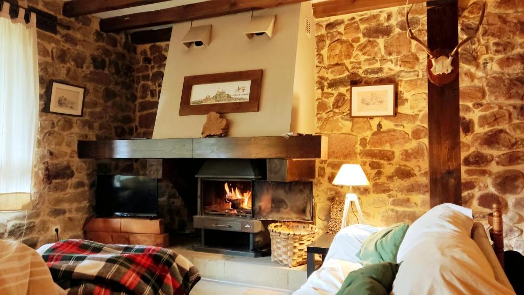 a living room with a fireplace and a couch at El Rincón del Besaya in Villasuso de Cieza