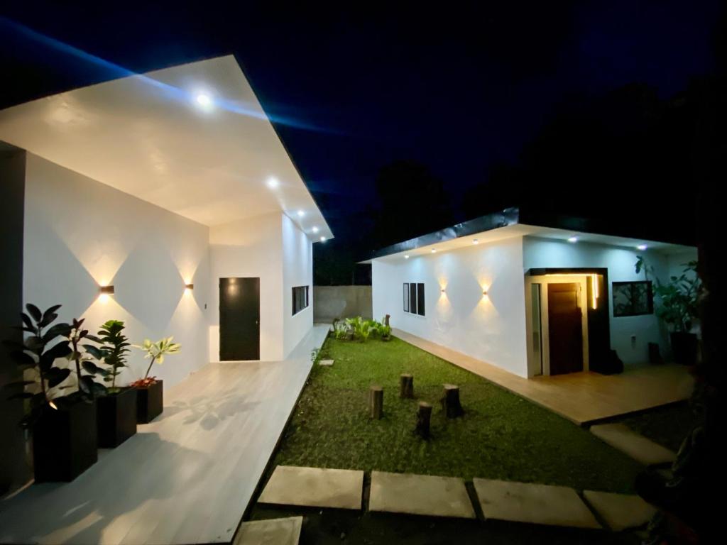 a white house with a yard at night at Unica Hija Hometel by TahZora in Valencia