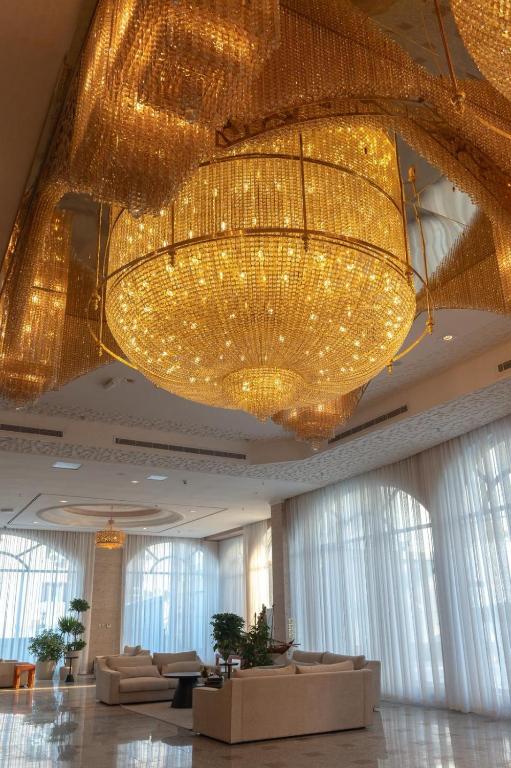 a large chandelier in a hotel lobby with couches at Sara Palace Apartments- family only in Kuwait