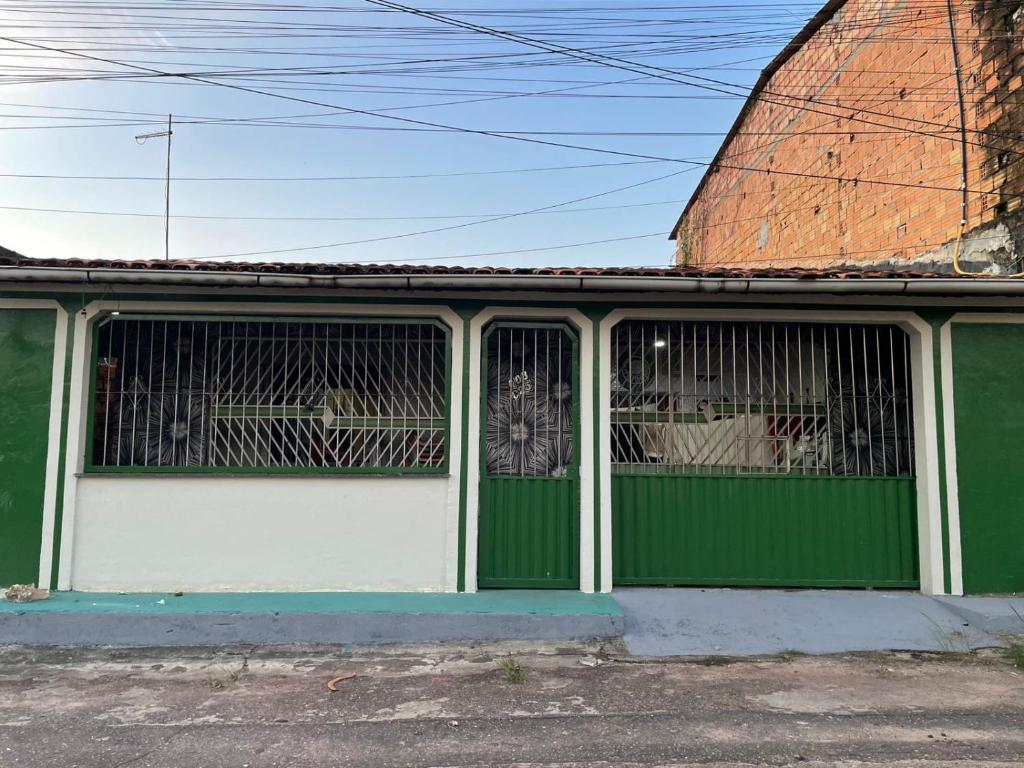 a green and white garage door with windows at Casa Coelho season for cop30 in Marituba