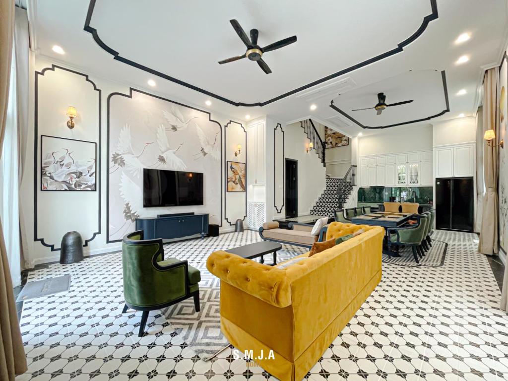 ein Wohnzimmer mit einem gelben Sofa und einem Fernseher in der Unterkunft Villa Vanda Phu Quoc in Phu Quoc