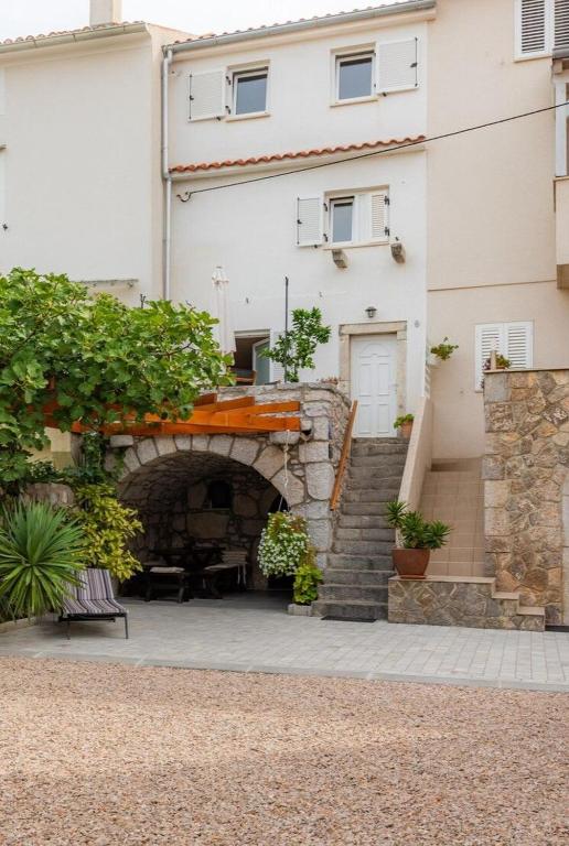 a building with a stone archway and a staircase at House Punat Residence in Punat