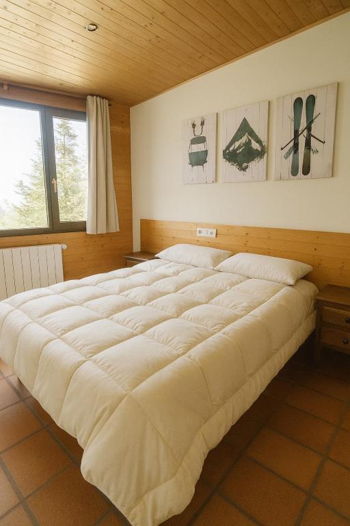 a large bed in a room with a wooden ceiling at Hostal Yeti in Sierra Nevada