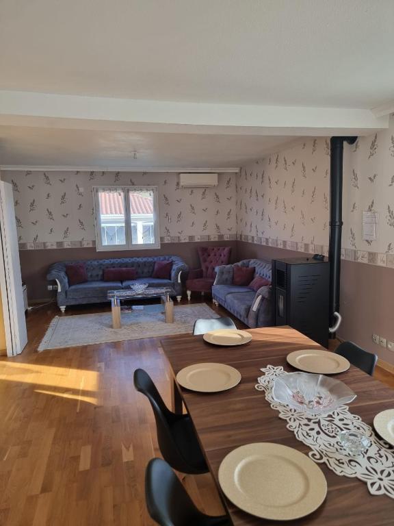 a living room with a table and a couch at Maison plein-pied 8 pers avec piscine sur demande in Thiers