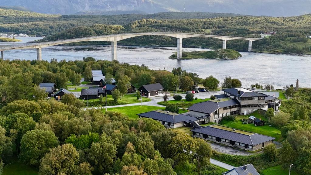 an aerial view of a house with a river and a bridge at Saltstraumen Hotel og Fjordhytter in Saltstraumen