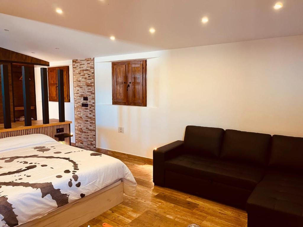 a bedroom with a bed and a couch at Escapada rural con sauna y relax en la naturaleza in Níjar