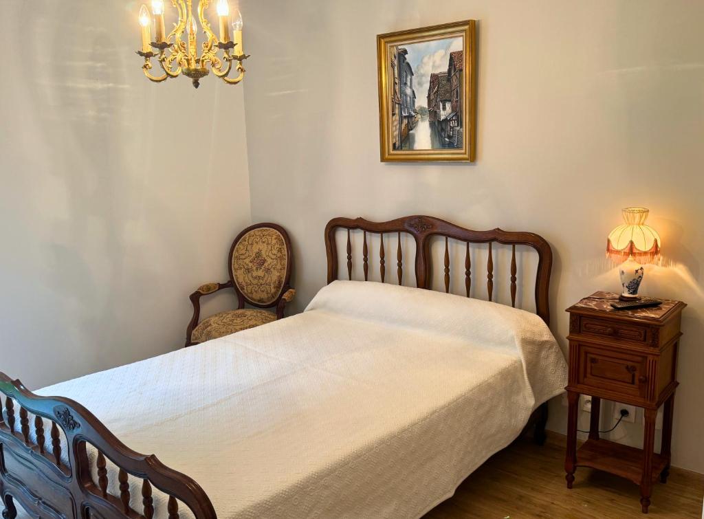 a bedroom with a bed and a chair and a lamp at Rétro - Parking - Wifi - Centre in Dax