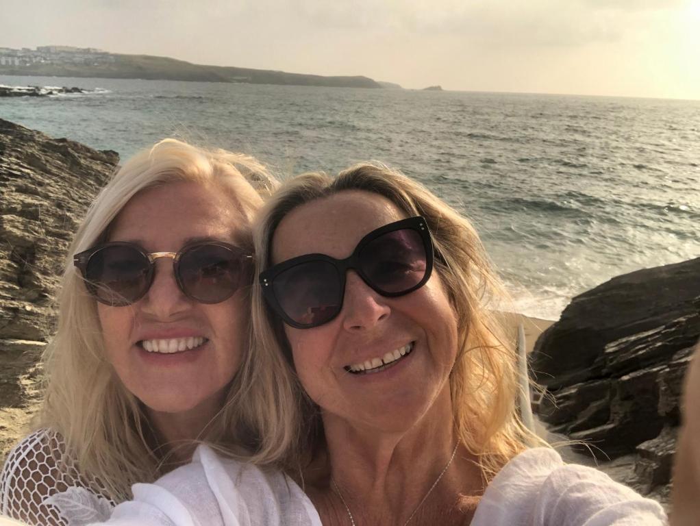 twee vrouwen met een zonnebril zittend naast de oceaan bij Num 29 in Newquay