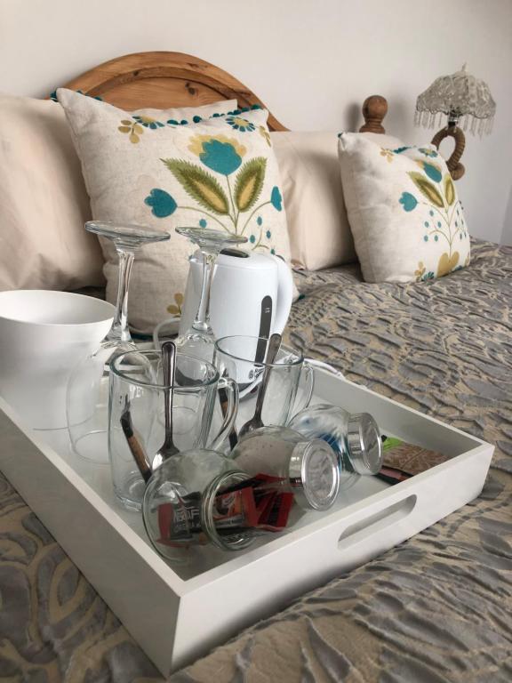 Una bandeja sobre una cama con vasos encima. en Num 29, en Newquay
