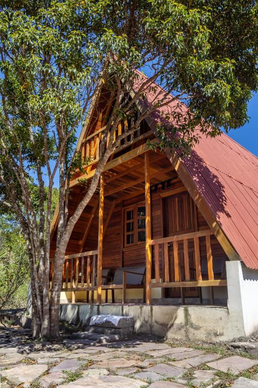 a log cabin with a red roof at Chalé dos Campos in Vale do Capao