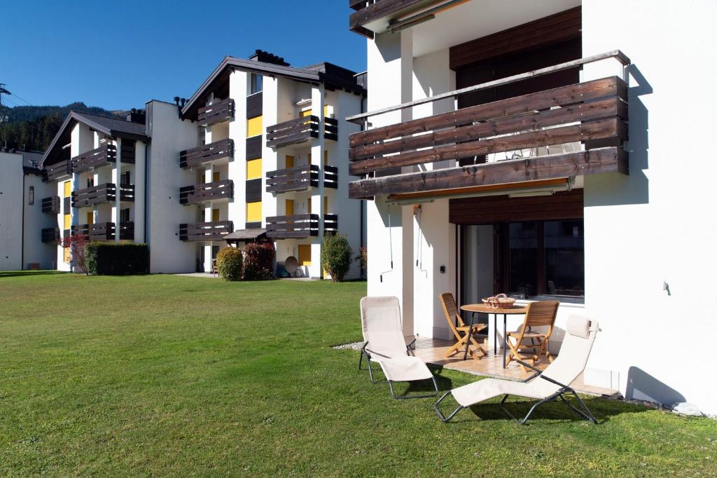 a patio with chairs and a table in a yard at Prada Laax by Quokka 360 - Alpine Residence with Shared Sauna in Laax