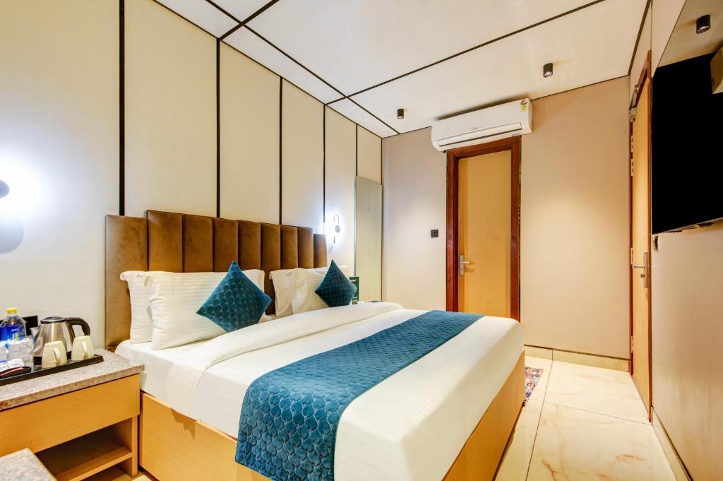 a bedroom with a large bed with a blue blanket at JS Residency Luxe Collection Hotel Near Nizamuddin Railway Station in New Delhi