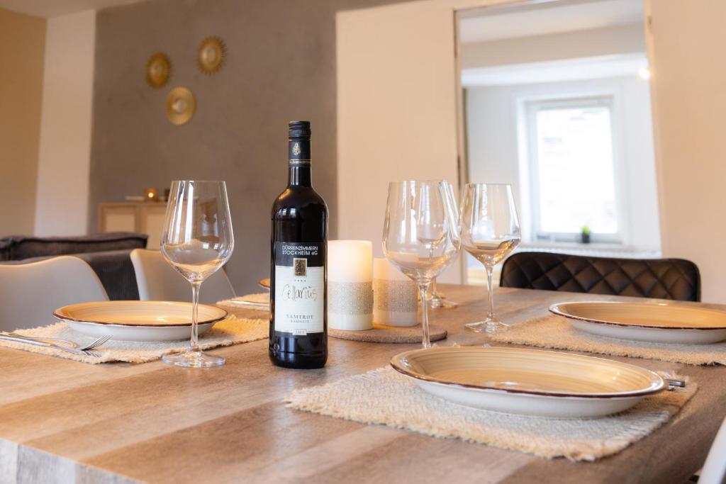 a bottle of wine sitting on a table with glasses at Ferienwohnung Tatort in Sankt Andreasberg