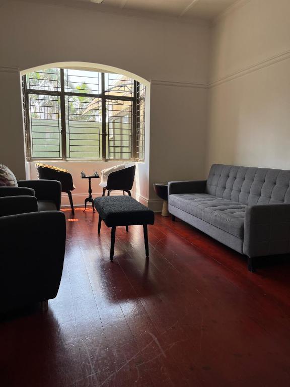 a living room with a couch and chairs and a table at Musgrave Escape in Durban