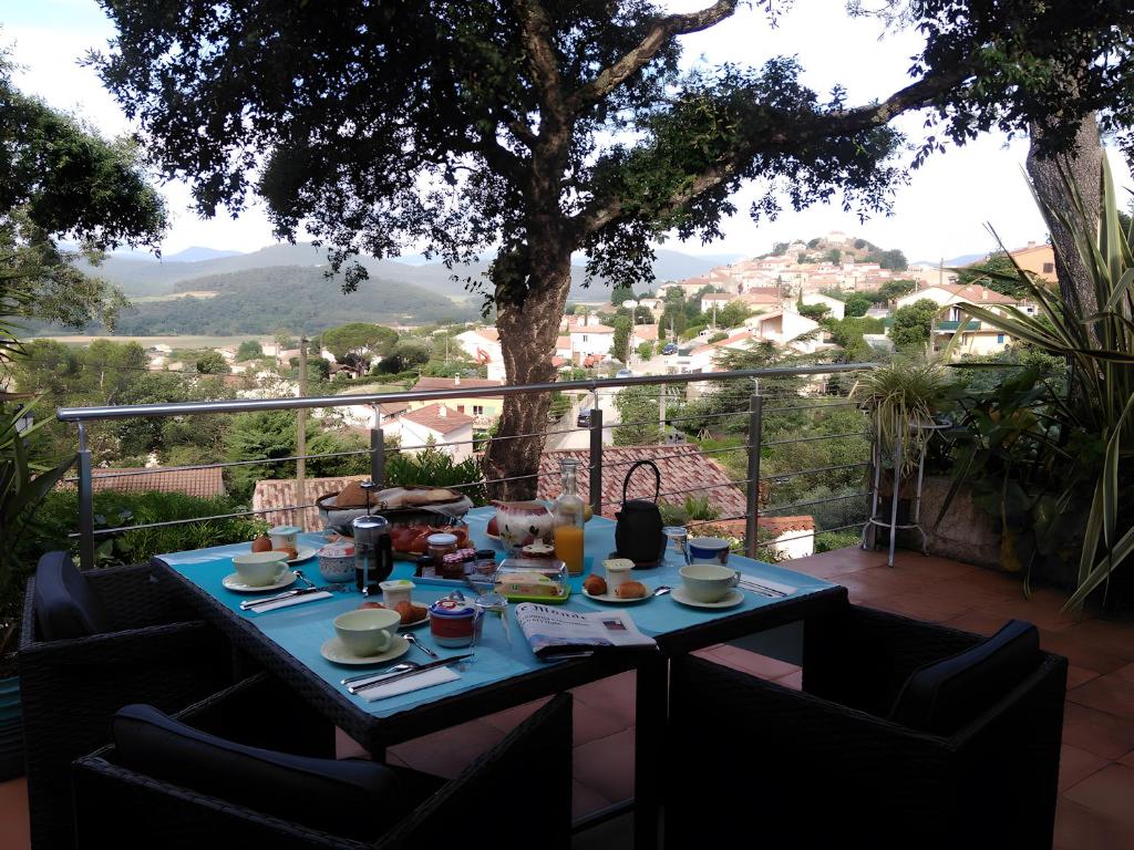a table with food on it on a balcony at Au Jardin Des Couleurs in Pierrefeu-du-Var