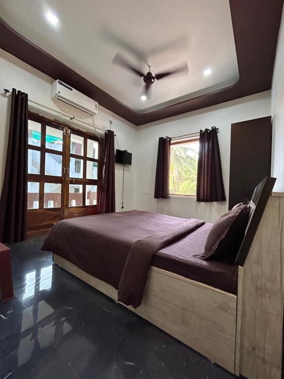 a bedroom with a bed with a ceiling fan at Gajalee Beach House in Bhogwe