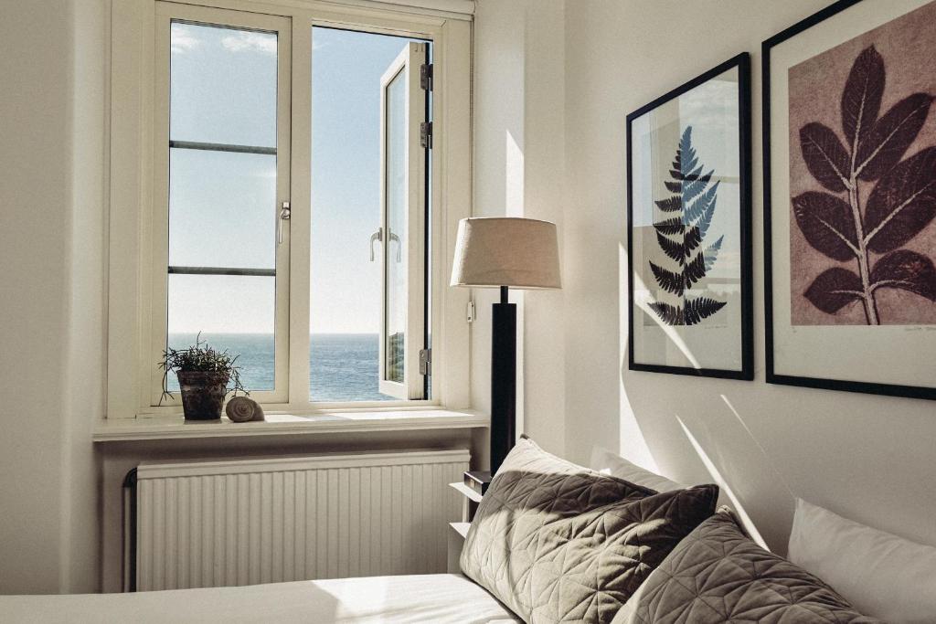 ein Schlafzimmer mit einem Bett und einem Fenster mit Blick auf das Meer in der Unterkunft Varbergs Kusthotell in Varberg