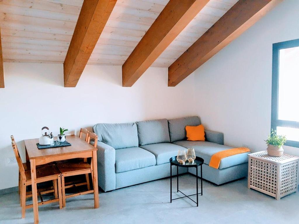 Una sala de estar con un sofá azul y una mesa. en Peaceful Stay in the Golan, en Sha'al