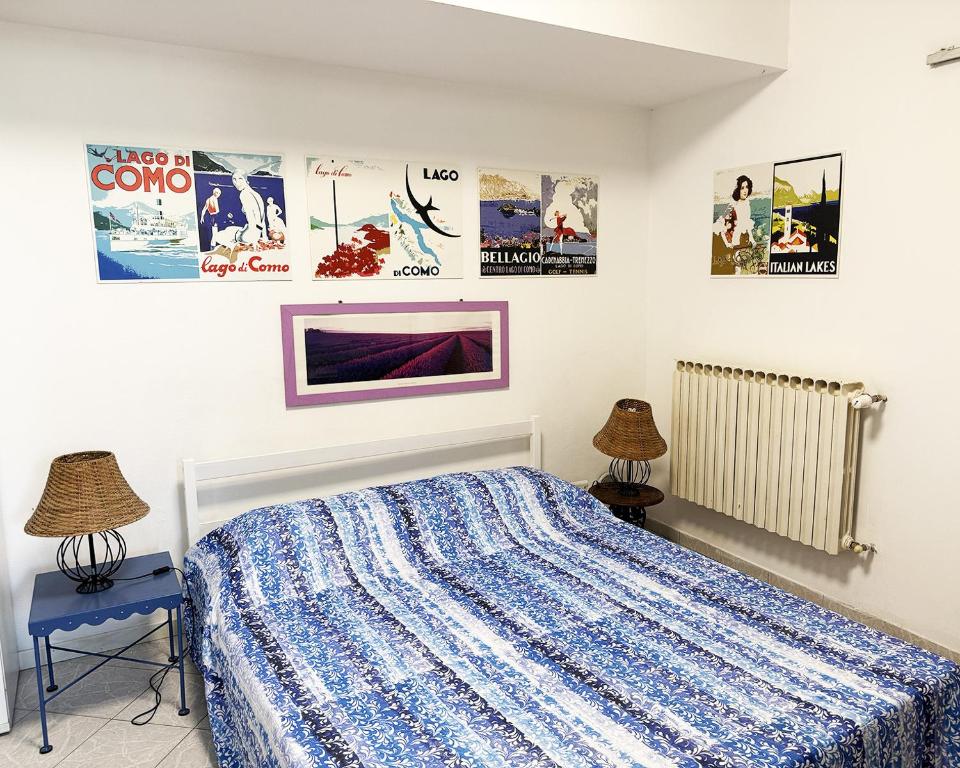 a bedroom with a bed and posters on the wall at Alture di Como-splendido appartamento in Como