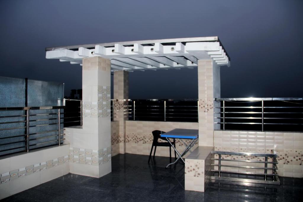 a table and a chair in a room with a balcony at Hotel Blue Castle International Two in Pāksey