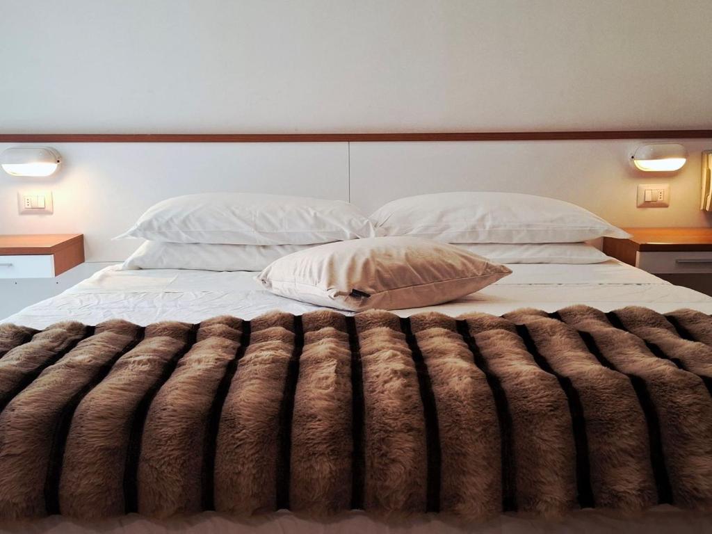 een slaapkamer met een bed met een bruine deken bij Hotel Brotas in Rimini