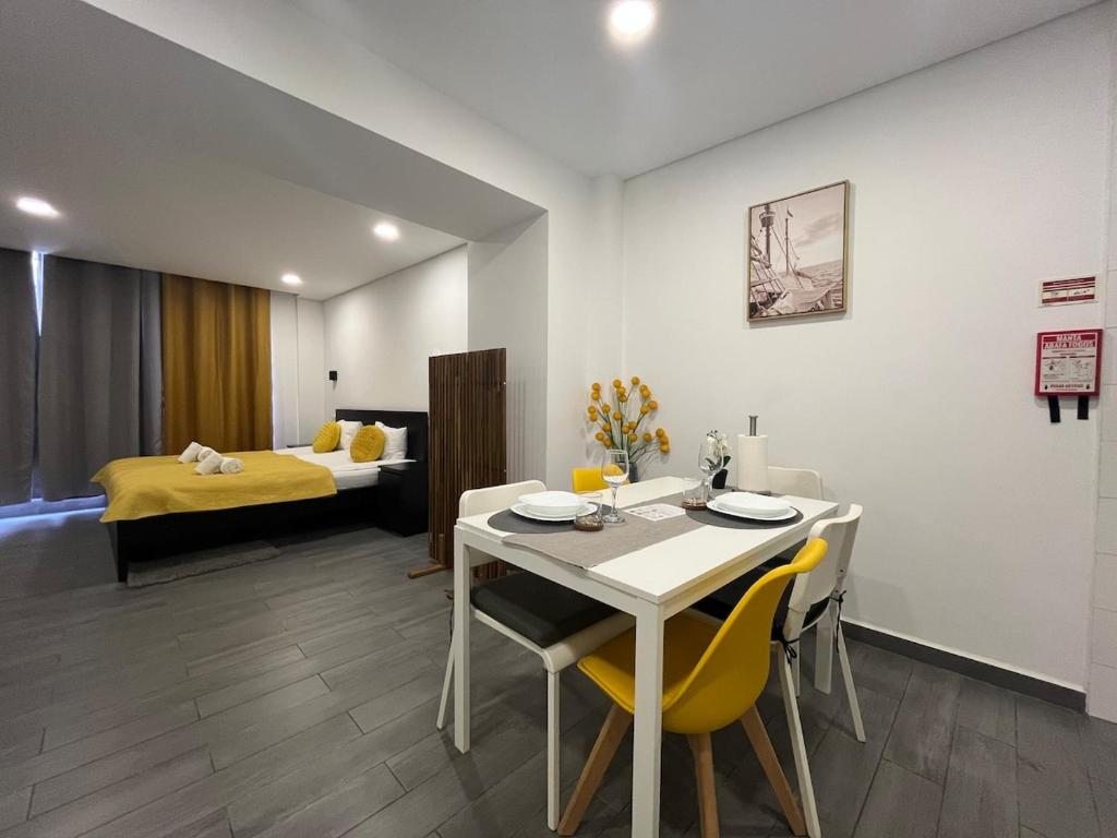 une pièce avec une table, des chaises et un lit dans l'établissement Almada Downtown 104, à Porto