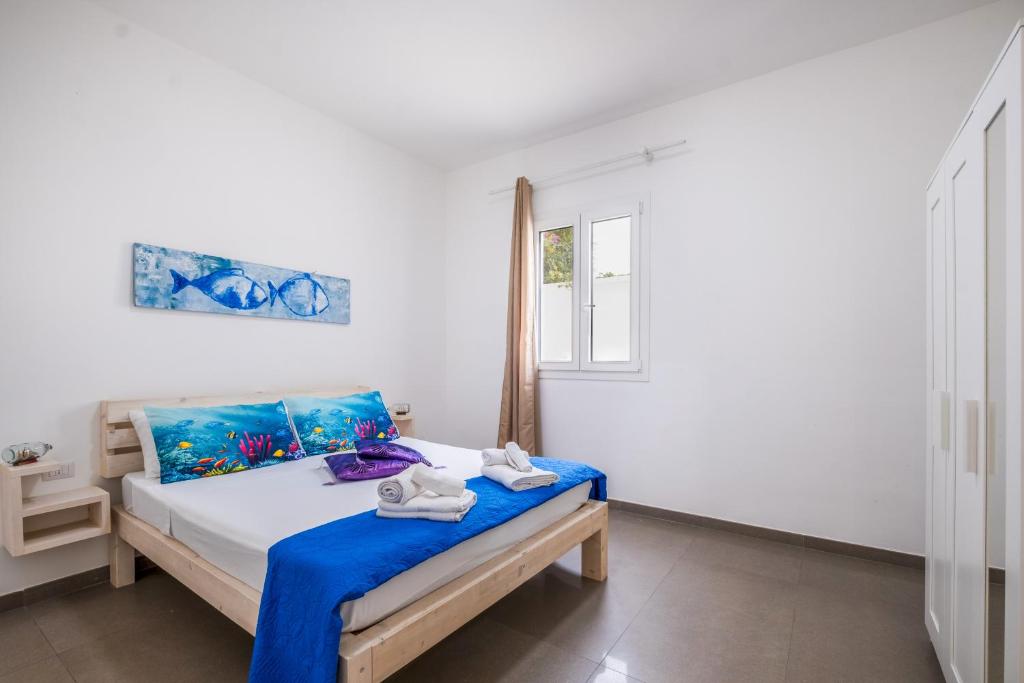 a bedroom with a bed with blue and white sheets at Mirèa - Lux Coastal Villa in Torre Lapillo