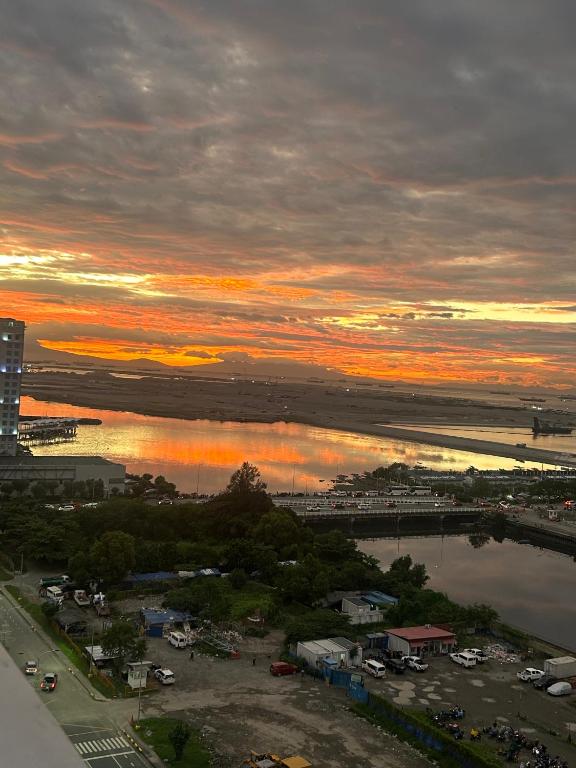a sunset over a parking lot and a body of water at City view in Manila