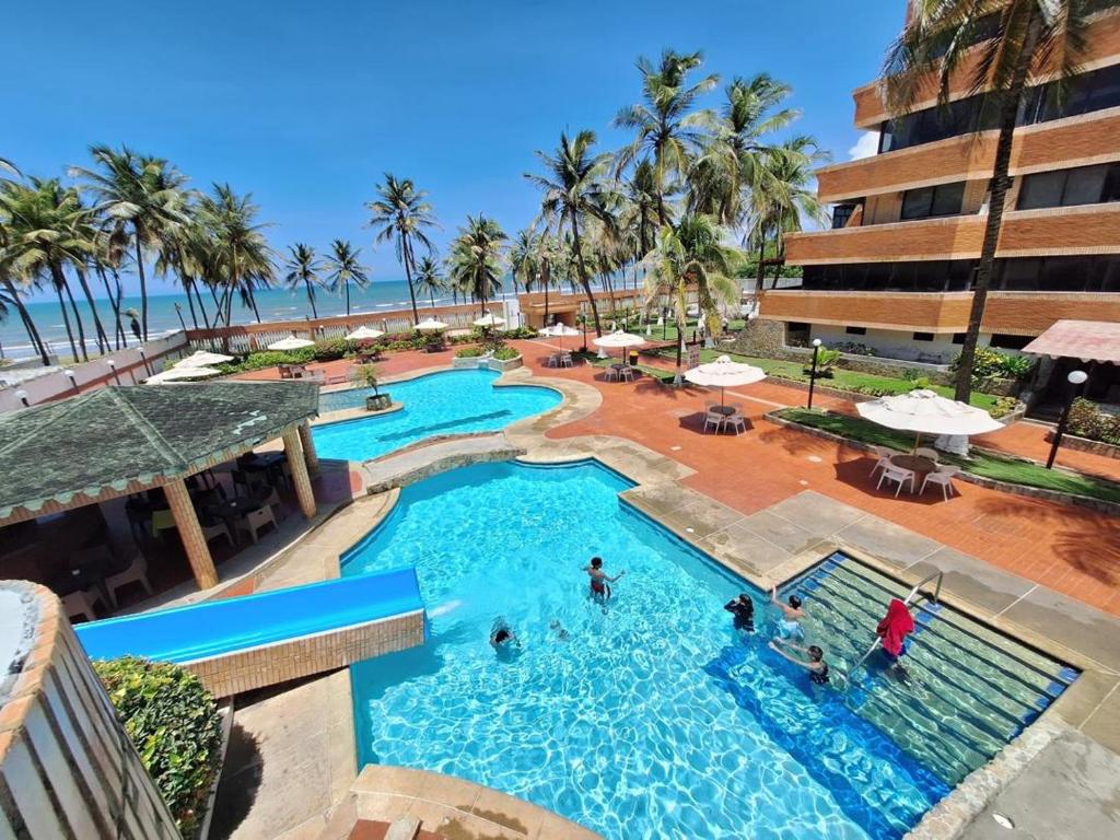 ein Pool in einem Resort mit Menschen darin in der Unterkunft Apartamento vacacional Tucacas in Tucacas