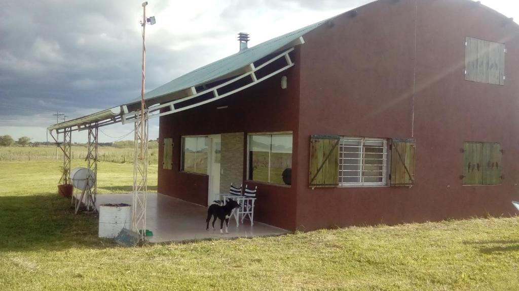 a red barn with a horse standing outside of it at El tobogan in General Madariaga